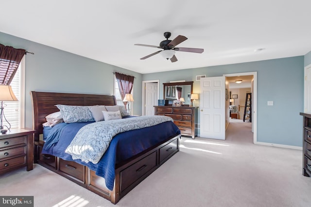 bedroom featuring visible vents, light carpet, a ceiling fan, a closet, and baseboards