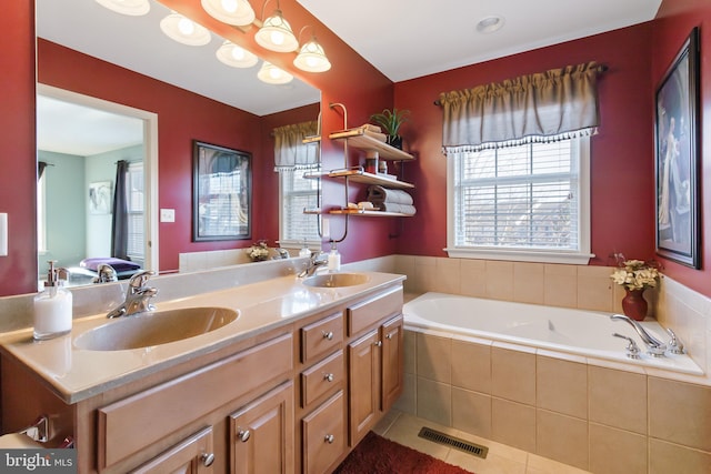 full bath featuring a sink, visible vents, a bath, and double vanity