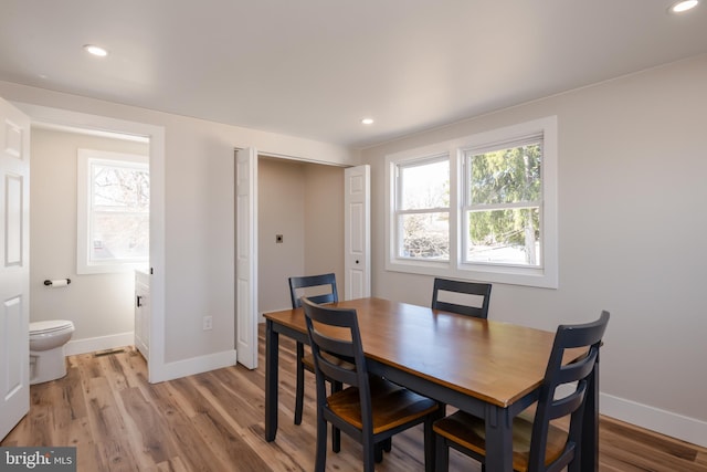 dining room with light wood-style flooring, recessed lighting, and baseboards