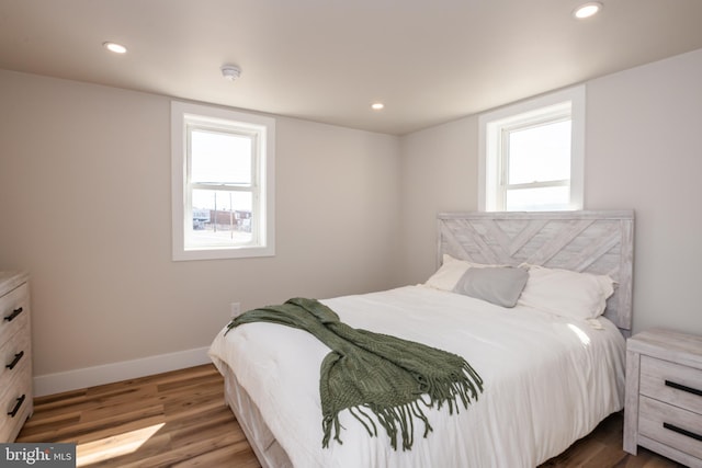 bedroom featuring recessed lighting, multiple windows, baseboards, and wood finished floors