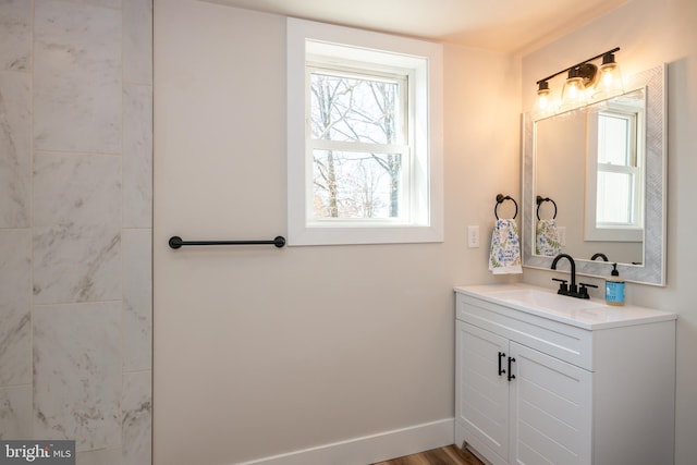 bathroom featuring a healthy amount of sunlight, vanity, and baseboards