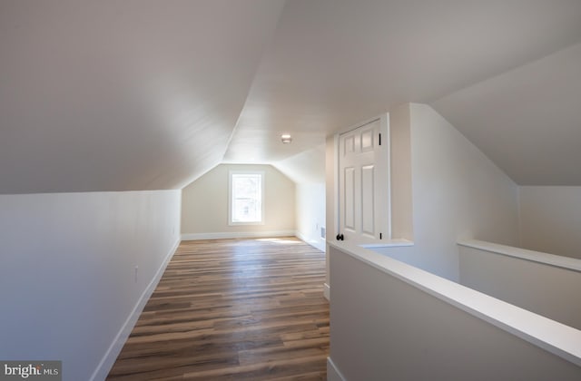 bonus room featuring vaulted ceiling, dark wood-style floors, and baseboards