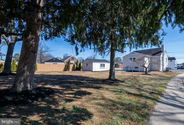 view of yard featuring central AC and fence