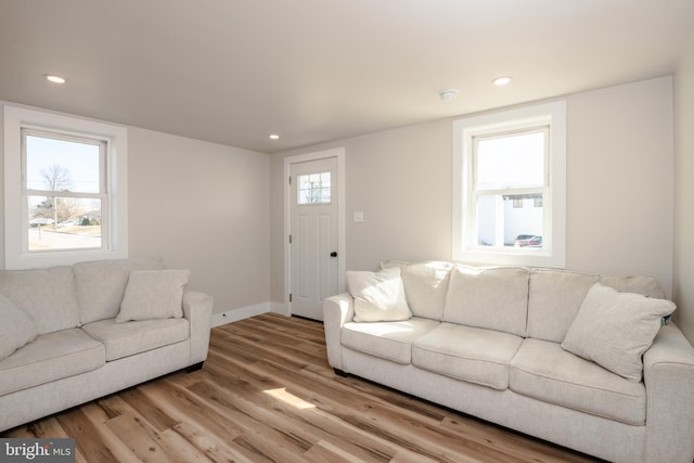 living room with recessed lighting, wood finished floors, baseboards, and a wealth of natural light