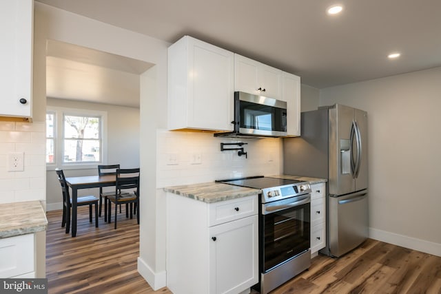 kitchen featuring backsplash, stainless steel appliances, and wood finished floors