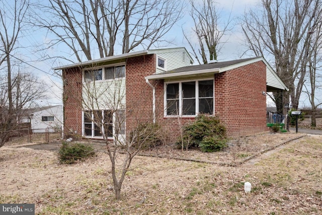 exterior space featuring brick siding and fence