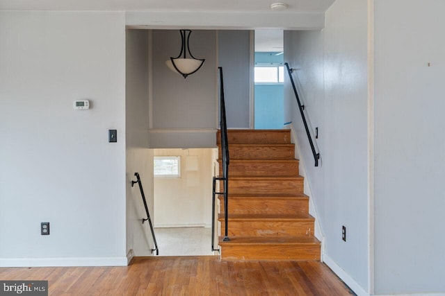 staircase with baseboards and wood finished floors