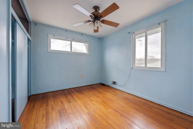 unfurnished bedroom with hardwood / wood-style flooring, baseboards, and a closet