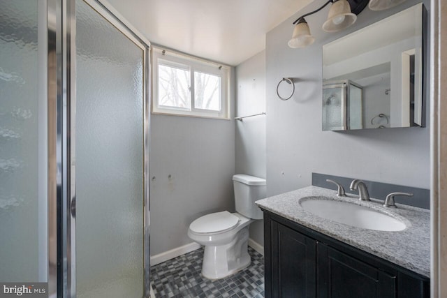 full bathroom with vanity, a shower stall, toilet, and baseboards