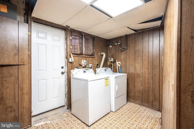 laundry room featuring washing machine and dryer, laundry area, and wood walls