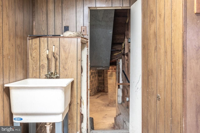 bathroom featuring wood walls and a sink