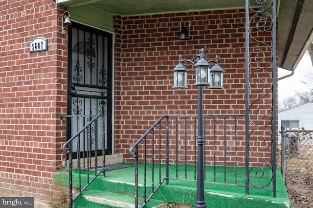 doorway to property with brick siding