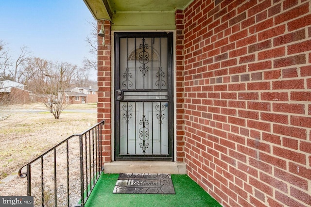 entrance to property featuring brick siding