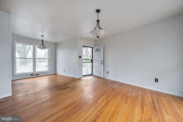 interior space with a wealth of natural light, light wood-type flooring, and baseboards