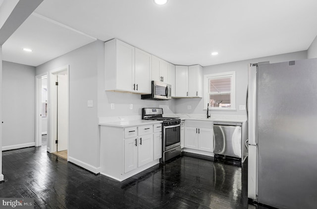 kitchen featuring white cabinetry, stainless steel appliances, light countertops, and dark wood-style flooring