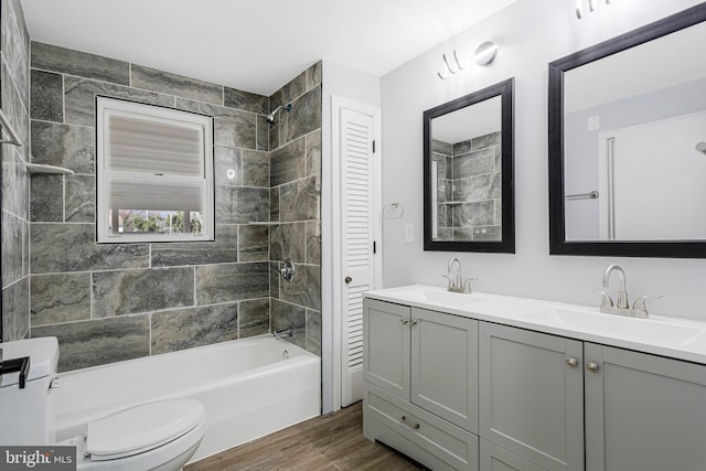 full bath featuring double vanity, toilet, shower / bathtub combination, and a sink