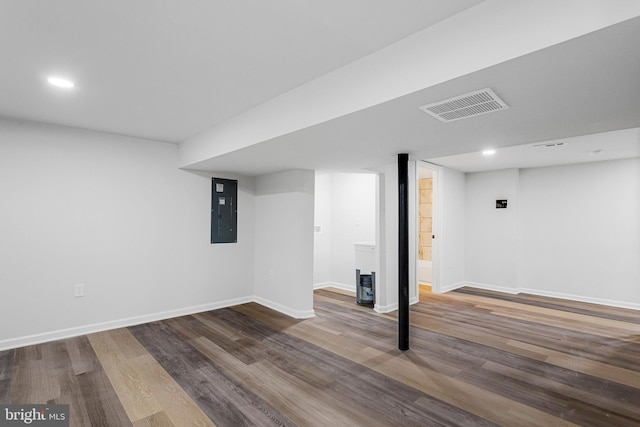 finished basement featuring visible vents, baseboards, electric panel, recessed lighting, and wood finished floors