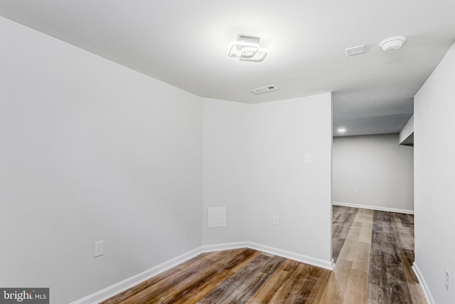 empty room with visible vents, wood finished floors, and baseboards