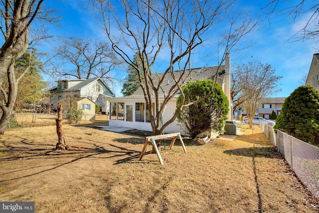 back of property with central air condition unit, fence, and a sunroom