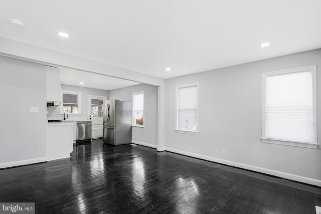 unfurnished living room with dark wood finished floors and baseboards