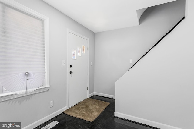 entryway featuring baseboards and concrete flooring