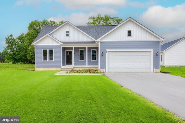 view of front of home with a front lawn, driveway, a porch, roof with shingles, and a garage