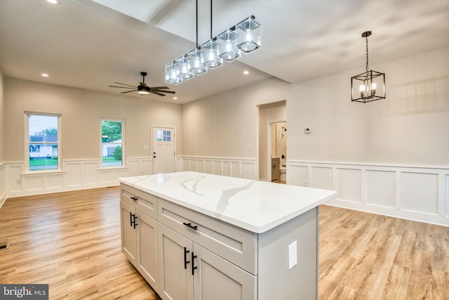 kitchen featuring light wood finished floors, recessed lighting, decorative light fixtures, open floor plan, and a center island