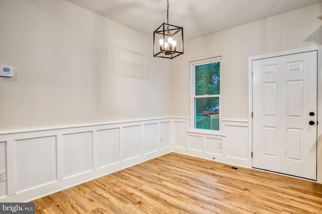 unfurnished dining area with visible vents, light wood-style floors, and a chandelier