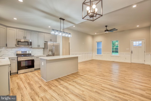 kitchen featuring light countertops, light wood finished floors, appliances with stainless steel finishes, and a kitchen island