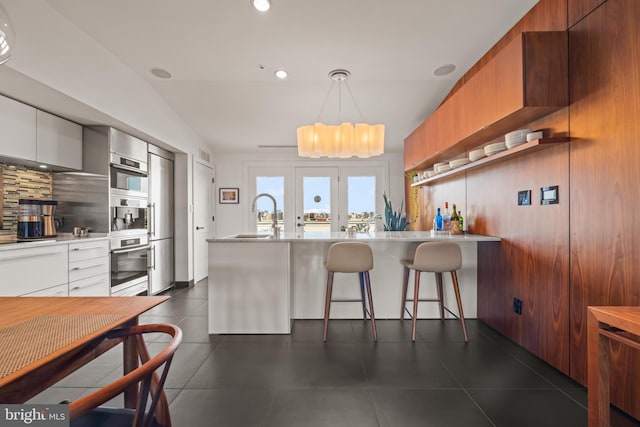 kitchen featuring modern cabinets, light countertops, and a sink