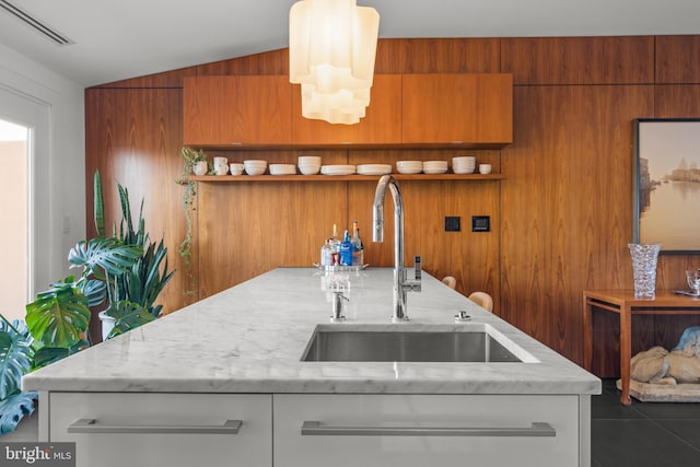 kitchen with brown cabinetry, visible vents, open shelves, a sink, and vaulted ceiling