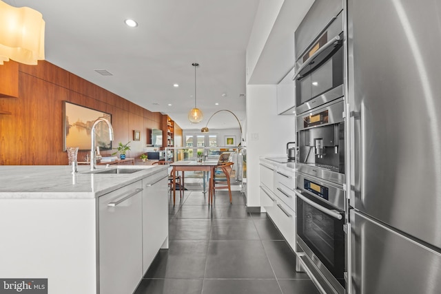 kitchen featuring modern cabinets, a sink, recessed lighting, appliances with stainless steel finishes, and white cabinets