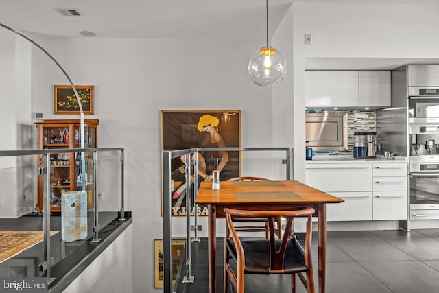 dining area featuring dark tile patterned flooring and visible vents