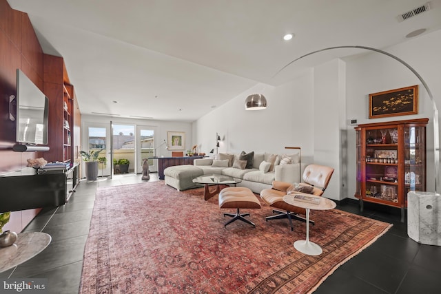 living area featuring dark tile patterned flooring and visible vents