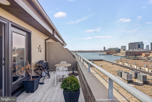 balcony with a view of city, central air condition unit, a water view, and a grill