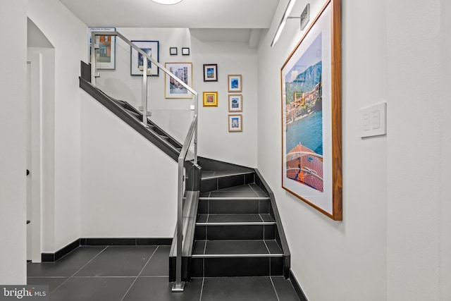 staircase featuring baseboards and tile patterned flooring