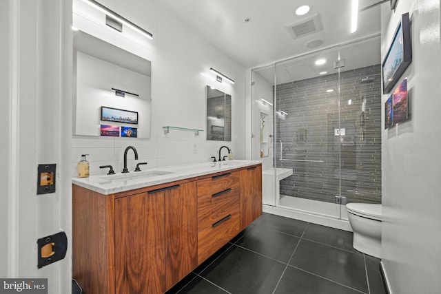 full bath with visible vents, double vanity, a sink, tile patterned flooring, and toilet