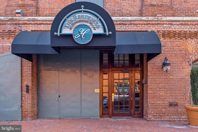 property entrance featuring brick siding