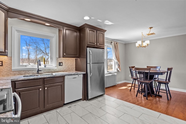 kitchen with radiator, freestanding refrigerator, white dishwasher, stove, and a sink