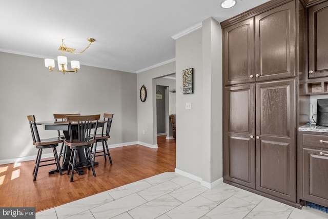 dining space with baseboards, marble finish floor, a chandelier, and crown molding