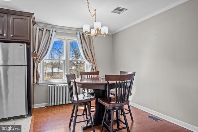 dining space with radiator heating unit, baseboards, visible vents, and a chandelier