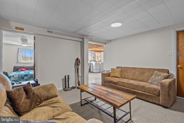 living area featuring plenty of natural light, washing machine and dryer, baseboards, and carpet floors