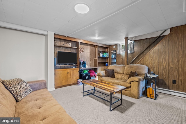 living area featuring baseboard heating, wood walls, and carpet floors