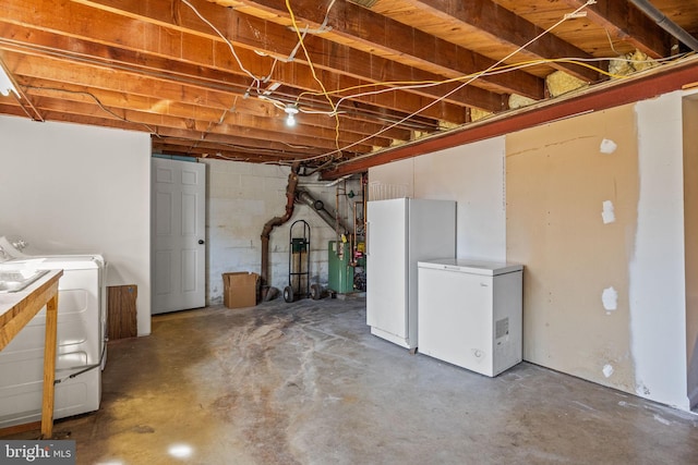 unfinished basement featuring refrigerator, separate washer and dryer, a heating unit, and freestanding refrigerator