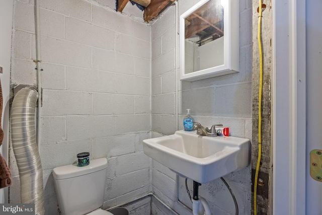 half bath with toilet and concrete block wall