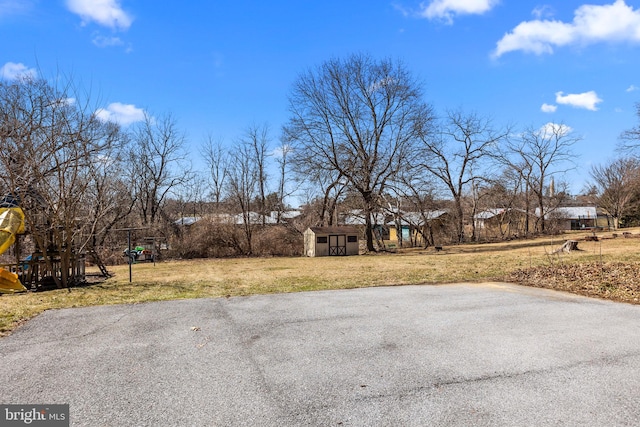 view of yard with playground community, a storage shed, and an outdoor structure