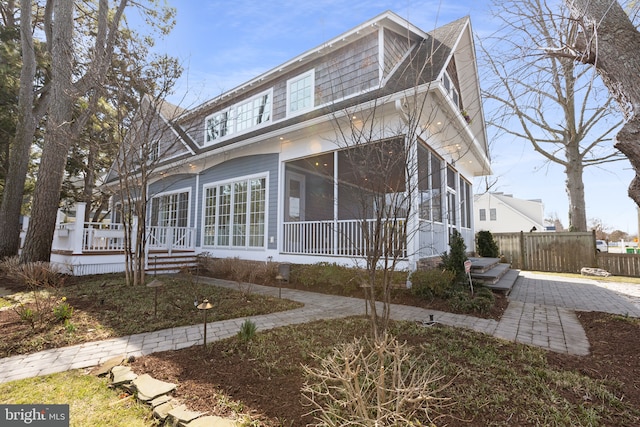 view of front facade with fence and a sunroom