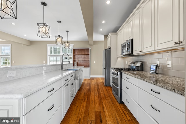 kitchen featuring decorative backsplash, white cabinets, a healthy amount of sunlight, and stainless steel appliances