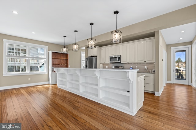 kitchen featuring open shelves, stainless steel appliances, light wood finished floors, decorative backsplash, and light countertops