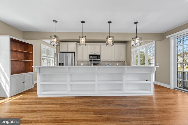 kitchen with open shelves, white cabinetry, appliances with stainless steel finishes, and light countertops